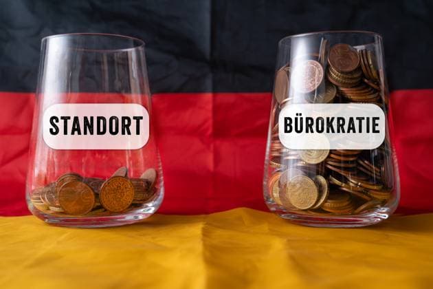 Bavaria, Germany - November 10, 2025: PHOTO MONTAGE, Two glasses filled with coins Location? and Bureaucracy.? The image illustrates how high costs and crippling administration are making Germany an increasingly unattractive location for businesses. *** FOTOMONTAGE, Zwei Gläser mit Münzen Standort und Bürokratie. Das Bild verdeutlicht: Hohe Kosten und lähmende Verwaltung machen den Standort Deutschland für Unternehmen zunehmend unattraktiv.