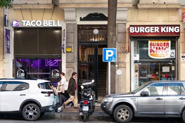 Brands and Logos in Madrid, Spain - 12 Nov 2025 Pedestrians walk past the American chain of fast-food restaurants Taco Bell andf Burger King in Spain. Madrid Spain Copyright: xXavixLopezx xSOPAxImagesx XL_7554