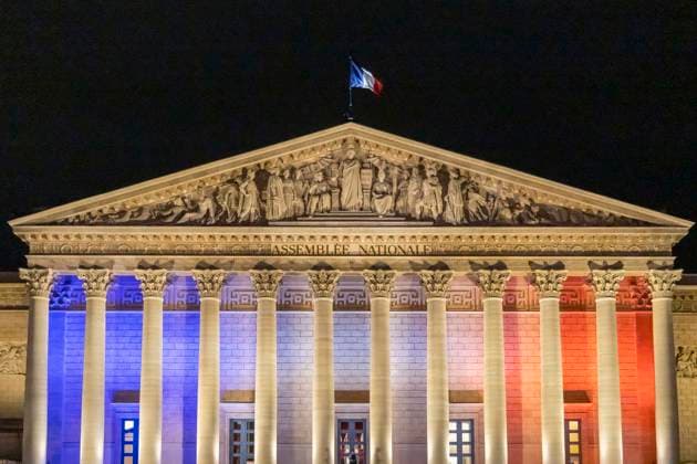 Paris, France November 13, 2025 - A flag flies atop the roof of the Palais Bourbon, seat of the National Assembly, as it is illuminated in the colours of the French flag during the commemoration of the tenth anniversary of the Paris terrorist attack. On Friday, November 13, 2015, three heavily armed Islamic State (IS) militants stormed the Bataclan concert hall in Paris during a performance by the American rock band Eagles of Death Metal, killing 90 people and taking hostages. The attack was the deadliest in a series of coordinated assaults across Paris that night, which left a total of 130 people dead. HOMMAGE ATTAQUES TERRORISTES, ILLUSTRATION, MONUMENT, ECLAIRAGE, ILLUMINATIONS, DRAPEAU FRANCAIS, TRICOLORE, ASSEMBLEE NATIONALE, PALAIS B  Copyright: xVincentxIsorex