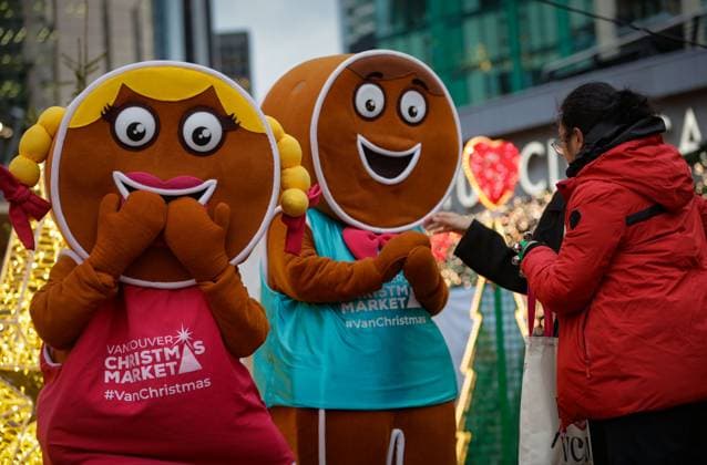 (251115) -- VANCOUVER, Nov. 15, 2025 -- Performers dressed as gingerbread men interact with visitors at the Vancouver Christmas Market in Vancouver, British Columbia, Canada, Nov. 14, 2025. The annual festive event features more than 110 wooden huts offering various handicrafts, traditional European food, drink, and souvenirs, along with live performances. This year s market opened here on Thursday and will run until Dec. 24. (Photo by Xinhua) CANADA-VANCOUVER-CHRISTMAS MARKET LiangxSen