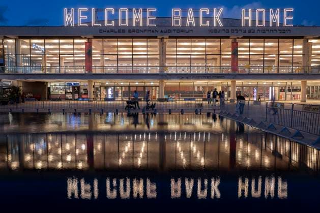 Israeli civilians seen before the Charles Bronfman Auditorium, which is next to the Mann Auditorium, in HaBima Square in Tel Aviv, Israel, as the Welcome Back Home large sign lights up at sundown on Saturday, November 15, 2025. Israel awaits the last 3 dead bodies that the Hamas should return to fulfill the first phase of the US-backed peace plan between Israel and the Hamas forces. Phase 2, when it begins, will be crucial as Hamas is supposed to disarm.  ISR20251115001 JimxHollander