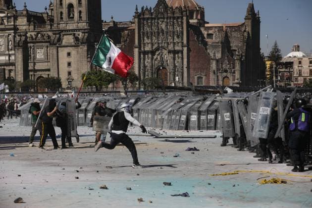 A person throws a stone against riot police during the Ã¢â‚¬ËœGen ZÃ¢â‚¬â ¢ demonstration at main square Zocalo against the Mexican government following the murder of Uruapan Mayor Carlos Manzola, while Mexico s President, Claudia Sheinbaum, has questioned the legitimacy of the movement in recent days . on November 15, 2025 in Mexico City, Mexico. Mexico City Mexico - ZUMAe321 20251115_zia_e321_050 Copyright: xIanxRoblesx