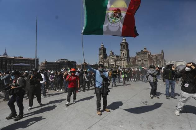 A person lifts a Mexican flag while taking part during Ã¢â‚¬ËœGen ZÃ¢â‚¬â ¢ demonstration at main square Zocalo against the Mexican government following the murder of Uruapan Mayor Carlos Manzola, while Mexico s President, Claudia Sheinbaum, has questioned the legitimacy of the movement in recent days . on November 15, 2025 in Mexico City, Mexico. Mexico City Mexico - ZUMAe321 20251115_zia_e321_062 Copyright: xIanxRoblesx