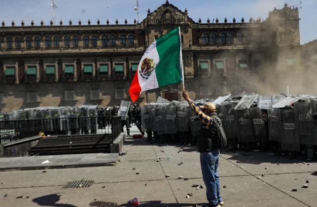 A person waves a Mexican flag during the Ã¢â‚¬ËœGen ZÃ¢â‚¬â ¢ demonstration at main square Zocalo against the Mexican government following the murder of Uruapan Mayor Carlos Manzola, while Mexico s President, Claudia Sheinbaum, has questioned the legitimacy of the movement in recent days . on November 15, 2025 in Mexico City, Mexico. Mexico City Mexico - ZUMAe321 20251115_zia_e321_080 Copyright: xIanxRoblesx