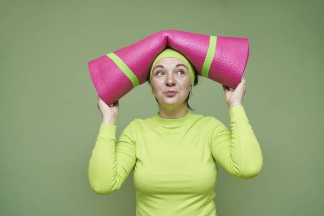 Weibliche Yogalehrerin. Lustiges Portrait einer Sportfrau. Helle Fitnessgeräte Selbstbewusster Trainingsstil. Eine Person mit Matte in der Nähe des Kopfes Female yoga teacher. Funny sport woman portrait. Bright fitness equipment. Confident workout lifestyle. One person with mat holding near head Copyright: imageBROKER ElenaxSafonova ibxiqx15550245.jpg ,model released, Symbolfoto ,property released