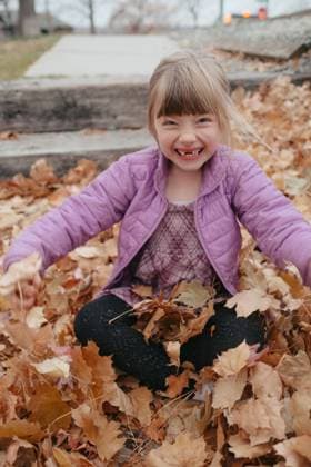 Young girl smiling playing in autumn leaves Boise, Idaho, United States CR_AUAU251118-1896151-01 ,model released, Symbolfoto