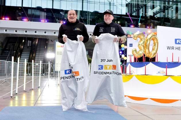 Presenter Wolfram Kons and singer Joey Kelly doing a sack race at a photo session to mark 30 years of the RTL telethon in the RTL building at Picassoplatz Cologne, 19 11 2025 NRW Germany Copyright: xChristophxHardtx