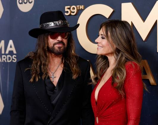 (L-R) Billy Ray Cyrus and Elizabeth Hurley arrive on the red carpet for the 59th CMA Awards in Nashville, Tennessee, on Wednesday, November 19, 2025.  NAS20251119228 JOHNxANGELILLO