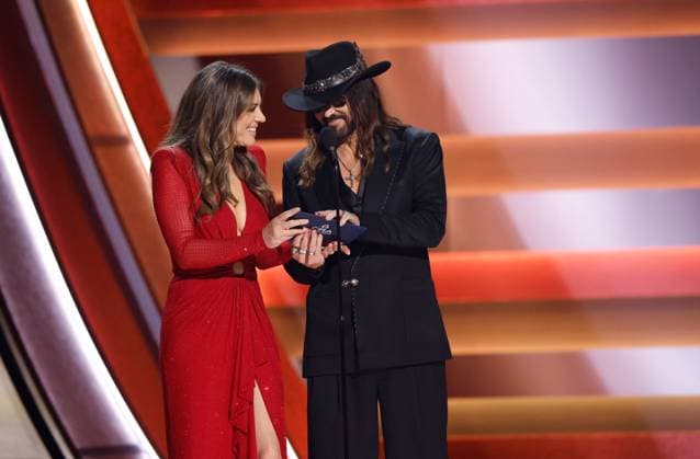 (L-R) Elizabeth Hurley and Billy Ray Cyrus appear onstage during the 59th CMA Awards at the Bridgestone Arena in Nashville, Tennessee, on Wednesday, November 19, 2025.  NAS20251119274 JOHNxANGELILLO