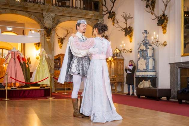 Winterausstellung auf Schloss Moritzburg, Mit Aschenbrödel zum Ball. Die Aschenbrödel-Saison startet im Schloss Moritzburg. Vom 21. November 2025 bis 1. März 2026 sind im Schloss wieder Originalkostüme, nachgebildete Filmszenen und Requisiten ausgestellt. Am authentischen Drehort wird der Märchenfilm Drei Haselnüsse für Aschenbrödel lebendig. Mit dem Motto Auf zum Ball! setzen die Ausstellungsmacher in der 14. Winterausstellung einen besonderen Akzent. Der barocke Speisesaal mit der imposanten Geweihsammlung wird erstmals komplett für Gäste begehbar. Gäste können in eigenen Kostümen, den beliebten Besucherkostümen oder natürlich in Zivil Walzer tanzen. Zum Pressetermin tanzten Anna Gregor und Felix Hauke. Moritzburg Sachsen