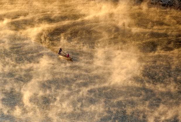 HUANGSHAN, CHINA - NOVEMBER 21: Aerial view villagers rowing a boat along the Fengle River amidst the morning mist on November 21, 2025 in Huangshan City, Anhui Province of China.  Copyright: xVCGx 111605138360