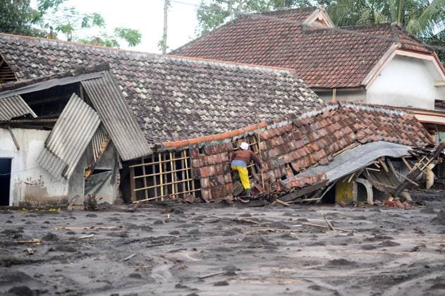 (251121) -- LUMAJANG, Nov. 21, 2025 -- A man checks his damaged house following the eruption of the Semeru volcano at Sapiturang village in Lumajang regency, East Java, Indonesia, Nov. 20, 2025. Indonesia s Semeru volcano erupted on Wednesday, prompting the country s volcanology agency to raise the alert level to the maximum. (Photo by Xinhua) INDONESIA-LUMAJANG-SEMERU VOLCANO-ERUPTION-AFTERMATH SahlanxKurniawan 