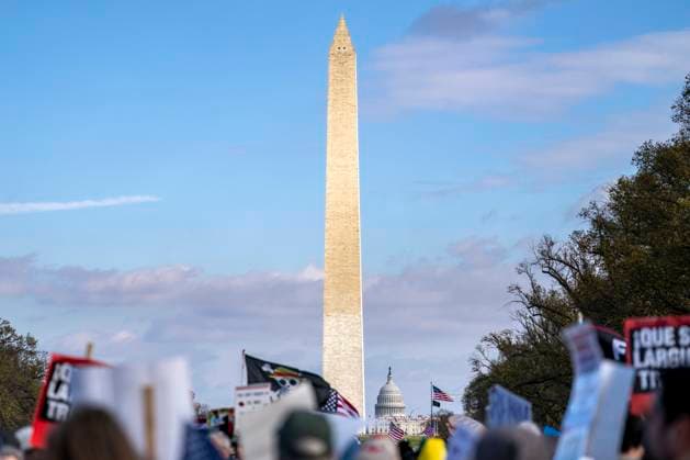 The Washington Monument and U.S. Capitol Dome is seen as people participate in the Remove the Regime protest outside the Lincoln Memorial in Washington, DC on Saturday, November 22, 2025. The demonstration called on Congress to impeach and remove President Donald Trump from office.  WAP20251122363 BONNIExCASH