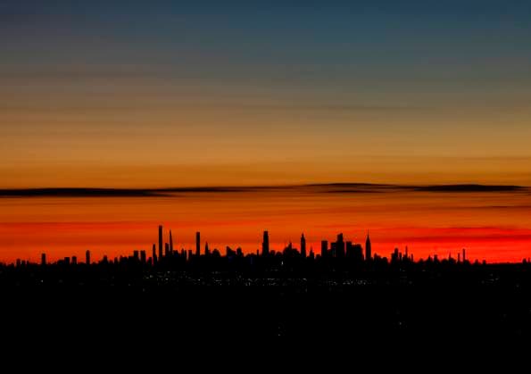 Clouds turn shades of red and orange before sunrise behind The Empire State Building and the Manhattan skyline on Sunday, November 23, 2025 in West Orange, New Jersey.  NYP20251123102 JOHNxANGELILLO