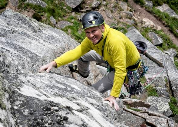 Climber ascending rocky mountain outdoors in Cornwall Bosigran model released, Symbolfoto, ALRF02185