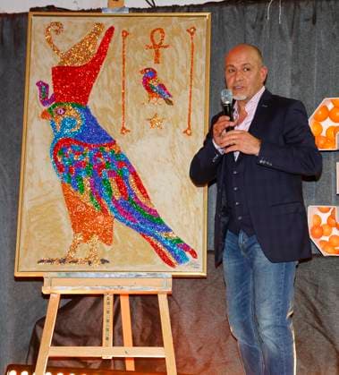 Erdogan Atalay with his picture at the celebration of 30 years of Die Arche in Berlin