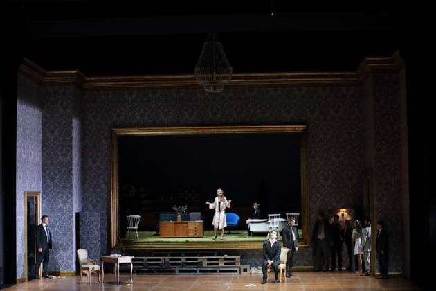 Vida Mikneviciute as Princess Fedora Romazov , Jonathan Tetelman seated in front, as Count Loris Ipanov and ensemble during the photo rehearsal for Fedora at the Deutsche Oper in Berlin, November 25, 2025 Melodrama in three acts by Umberto Giordano Musical direction John Fiore Production Christof Loy Stage and costumes Herbert