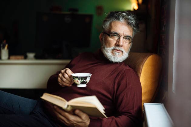 Senior man enjoying a warm drink while reading a book Belgrade, City of Belgrade, Serbia CR_NEST251124-1899362-01 ,model released, Symbolfoto ,property released