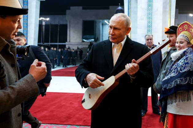 KYRGYZSTAN, BISHKEK - NOVEMBER 26, 2025: Russia s President Vladimir Putin holds a string instrument while visiting the Ala Archa State Residence. Alexander Kazakov Russian Presidential Press and Information Office TASS  85971242
