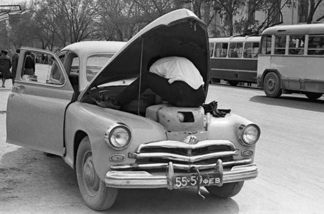 September 1-15, 1967. Murmansk, USSR. A car enthusias attempts to repair a stalled GAZ M-20 Pobeda car on one of the city streets. The exact date of the photograph is unknown. Semyon Maisterman TASS  32437002