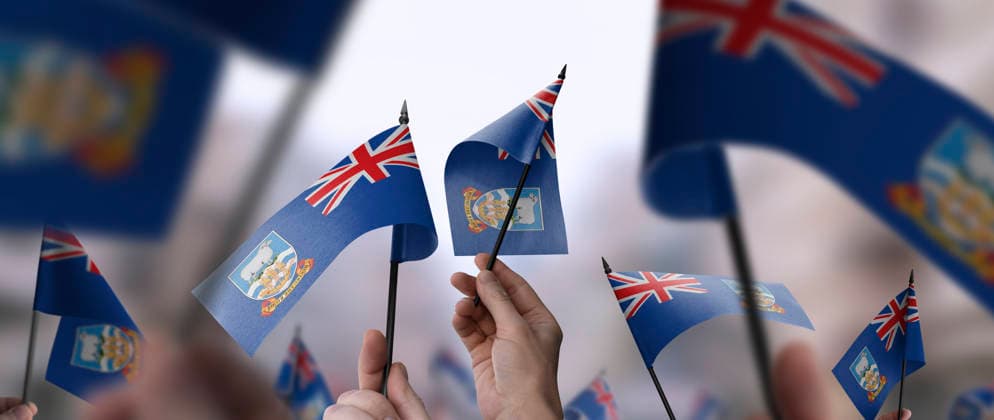 Flaggen der Falklandinseln in ihren Händen vor einem unscharfen städtischen Hintergrund Falkland Islands flags in their hands on a blurred urban background. The photo illustration was created without the use of artificial intelligence, only using Photoshop. (License=RF) Copyright: xZoonar.com AlekseyxButenkovx 24303803