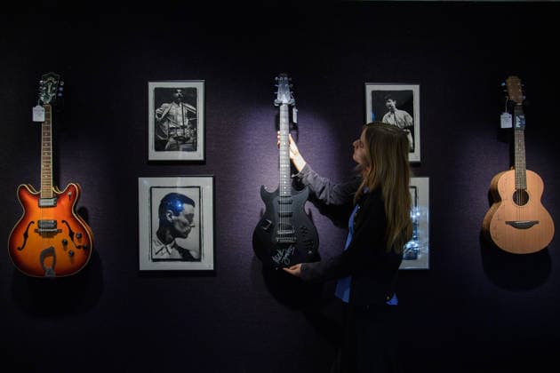 Bonhams Sound & Cinema: With Property from The Marianne Faithfull Estate Sale - Bonhams, London, UK - 1 December 2025 A staff member views (L) - A Guild Starfire IV Electric Guitar Used On Blur s This Is A Low owned by Andy Ross (who discovered Blur) and played by Graham Coxon of Blur (est. Â£3k - Â£5k) (M) - A Signed Bond Electraglide Electric Guitar owned by Mick Jones of The Clash (est. Â£4k - Â£6k) and (R) - A Signed Sheeran Lowden W01 Acoustic Guitar by Ed Sheeran (Â£2k - Â£3k) which is on auction at Bonhams Sound & Cinema: With Property from The Marianne Faithfull Estate Sale ending from 3rd December 2025 at Bonhams in London, England, UK on Monday 1 December, 2025., Credit:Justin Ng Avalon UK, England, London, Bonhams  Copyright: xJustinxNgx xAvalonx 1055809875