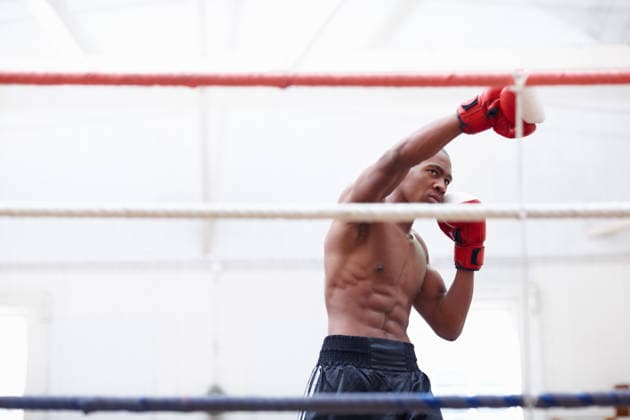 Black man, boxer and fight with gloves in boxing ring for fitness, strength training and battle match. Athlete, person and punch impact for mma challenge, power knockout and sports defense for combat. model released property released Copyright: xx