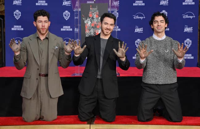 (L-R) Nick Jonas, Kevin Jonas and Joe Jonas of the Jonas Brothers participate in a hand and footprint ceremony immortalizing them in the forecourt of the TCL Chinese Theatre (formerly Grauman s) in the Hollywood section of Los Angeles on Wednesday, December 3, 2025.  LAP2025120301 JIMxRUYMEN