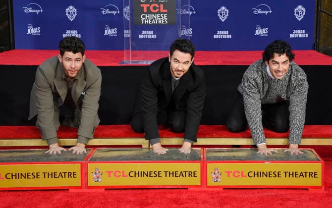 (L-R) Nick Jonas, Kevin Jonas and Joe Jonas of the Jonas Brothers participate in a hand and footprint ceremony immortalizing them in the forecourt of the TCL Chinese Theatre (formerly Grauman s) in the Hollywood section of Los Angeles on Wednesday, December 3, 2025.  LAP2025120305 JIMxRUYMEN
