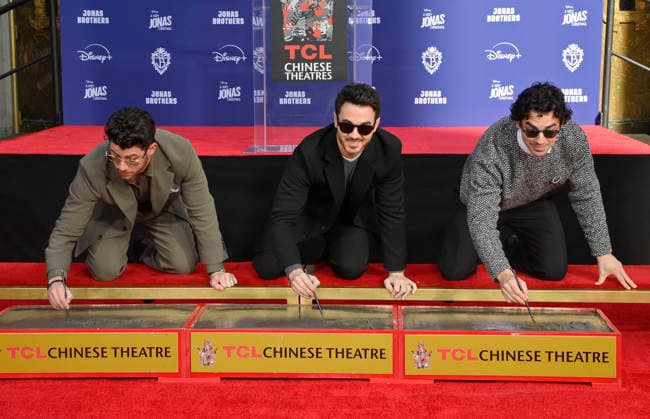 (L-R) Nick Jonas, Kevin Jonas and Joe Jonas of the Jonas Brothers participate in a hand and footprint ceremony immortalizing them in the forecourt of the TCL Chinese Theatre (formerly Grauman s) in the Hollywood section of Los Angeles on Wednesday, December 3, 2025.  LAP2025120306 JIMxRUYMEN