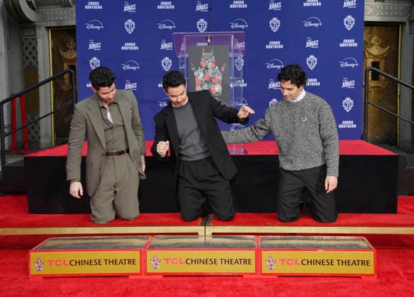 (L-R) Nick Jonas, Kevin Jonas and Joe Jonas of the Jonas Brothers participate in a hand and footprint ceremony immortalizing them in the forecourt of the TCL Chinese Theatre (formerly Grauman s) in the Hollywood section of Los Angeles on Wednesday, December 3, 2025.  LAP2025120309 JIMxRUYMEN