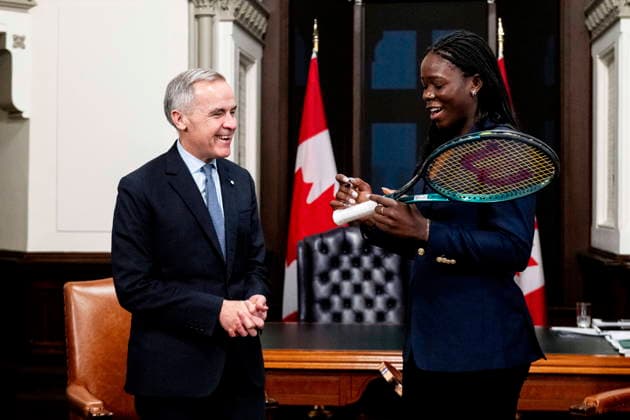 December 3, 2025, Ottawa, On, Canada: Prime Minister Mark Carney, left, reacts as Canadian tennis champion Victoria Mboko signs her tennis racket used to win the 2025 National Bank Open in Montreal during a meeting on Parliament Hill in Ottawa, on Wednesday, Dec. 3, 2025. Ottawa Canada  - ZUMAc35_ 20251203_zaf_c35_092 Copyright: xSpencerxColbyx