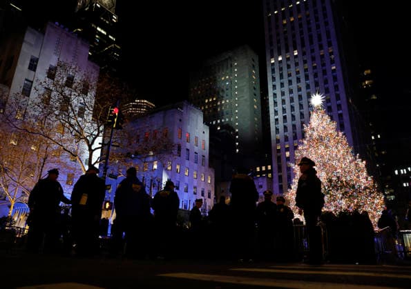 NYPD Police officers gather around the Rockefeller Center Christmas Tree after it is lit for the first time of the season at the 93rd annual Rockefeller Center Christmas Tree lighting ceremony takes place in New York City on Wednesday, December 3, 2025. The 75-foot-tall Norway Spruce came from a home in East Greenbush, New York.  NYP20251203119 JOHNxANGELILLO