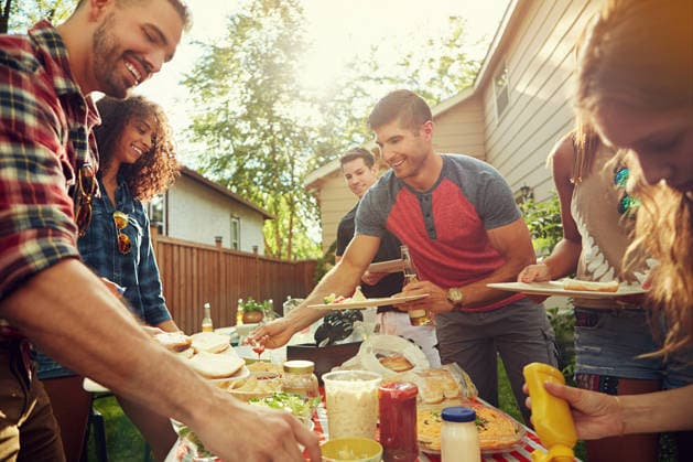 Dish, food and friends in backyard at barbecue with laughing, eating and bonding together. Happy, bbq and group of people with meal for social reunion, hangout or event outdoor at home on weekend model released property released Copyright: xx