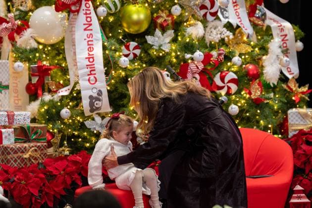 December 5, 2025, Washington, District Of Columbia, USA: First Lady MELANIA TRUMP helps a little girl onto a stool before reading a book to the crowd during her visit to the ChildrenÃ¢â‚¬â ¢s National Hospital. Washington USA - ZUMAs365 20251205_znp_s365_002 Copyright: xJoeyxSussmanx