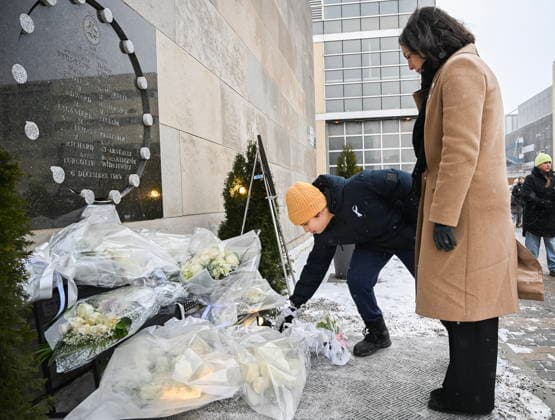 December 6, 2025, Montreal, Pq, Canada: Ryan Gasmi (11), and Valerie Belisle, a former student at Ecole Polytechnique lay flowers at a memorial plaque for the victims of the 1989 Ecole Polytechnique massacre in Montreal, Saturday, December 6, 2025. Today marks the 36th anniversary of the shooting by an anti-feminist which left 14 women dead and 13 others injured. Montreal Canada  - ZUMAc35_ 20251206_zaf_c35_002 Copyright: xGrahamxHughesx