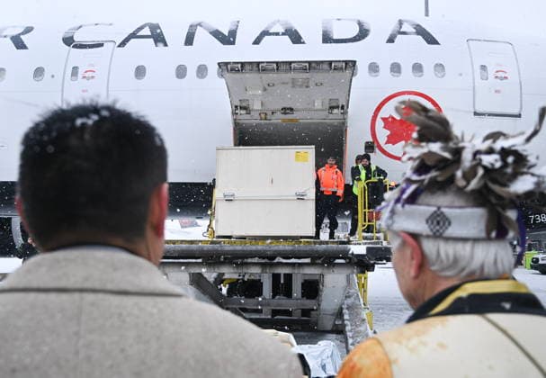 December 6, 2025, Montreal, Pq, Canada: Representatives from various First Nations look on as ground crew unload a kayak and other indigenous artifacts at Trudeau Airport in Montreal, Saturday, December 6, 2025, after they were returned by the Vatican. Montreal Canada  - ZUMAc35_ 20251206_zaf_c35_044 Copyright: xGrahamxHughesx