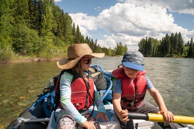 A young boy and young girl row a raft down a clear river. Whitefish, Montana, United States CR_AXTH251205-1863369-01 ,model released, Symbolfoto