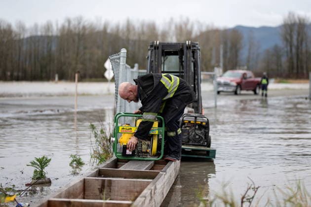 December 11, 2025, Vancouver, Bc, CANADA: A man places a pump during flooding in Abbotsford B.C., on Thursday, December 11, 2025. Vancouver CANADA  - ZUMAc35_ 20251211_zaf_c35_063 Copyright: xEthanxCairnsx