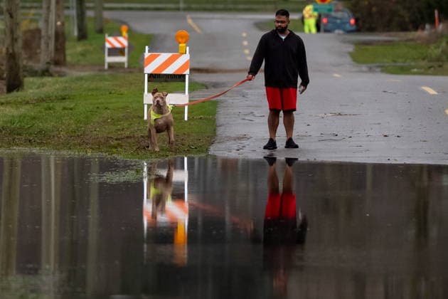 December 11, 2025, Vancouver, Bc, CANADA: A man walks his dog by a flooded street in Abbotsford B.C., on Thursday, December 11, 2025. Vancouver CANADA  - ZUMAc35_ 20251211_zaf_c35_064 Copyright: xEthanxCairnsx
