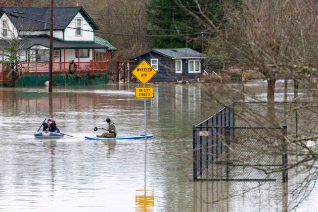 December 11, 2025, Sultana, Washington, USA: People paddle through flood waters from the Skykomish River inundating a portion of downtown Sultanaon Thursday. A trio of atmospheric rivers have drenched the region. Forecasts said that many rivers in the Pacific Northwest would reach catastrophic flood levels and the Washington governor has declared a state of emergency. Sultana USA - ZUMAb344 20251211_znp_b344_007 Copyright: xM.xScottxBrauerx
