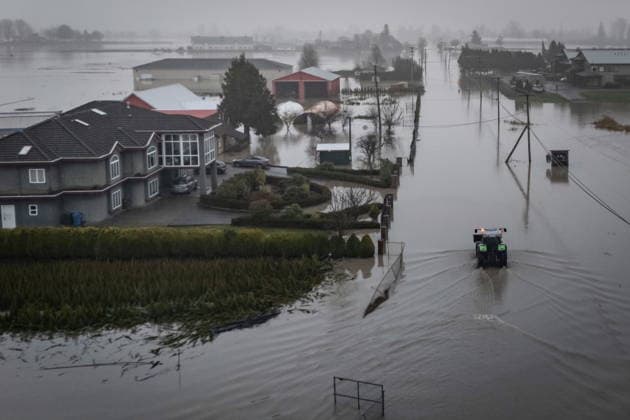 December 12, 2025, Abbotsford, Bc, CANADA: A tractor drives through floodwaters in Abbotsford, B.C., on Friday, Dec. 12, 2025. Abbotsford CANADA  - ZUMAc35_ 20251212_zaf_c35_054 Copyright: xEthanxCairnsx