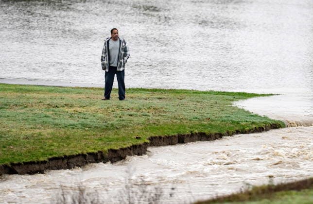 December 12, 2025, Abbotsford, Bc, CANADA: A man watches as floodwaters erode dirt forming a river off of the highway in Abbotsford, B.C., on Friday, Dec. 12, 2025. Abbotsford CANADA  - ZUMAc35_ 20251212_zaf_c35_069 Copyright: xEthanxCairnsx