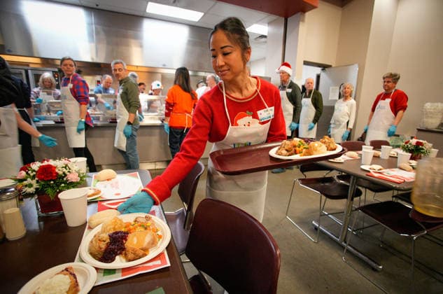 (251213) -- VANCOUVER, Dec. 13, 2025 -- A volunteer serves food during the annual Christmas meal event in Vancouver, British Columbia, Canada, on Dec. 12, 2025. (Photo by Xinhua) CANADA-VANCOUVER-CHRISTMAS MEALS LiangxSen 
