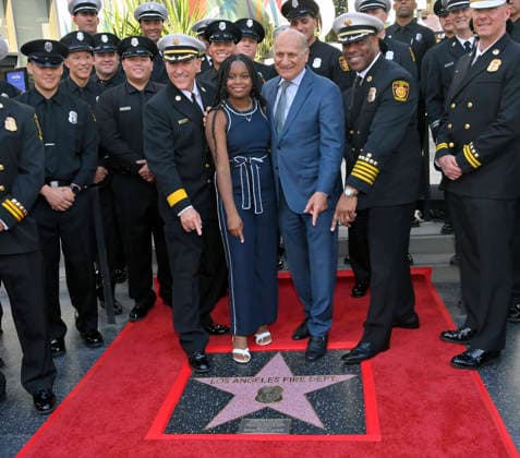 LAFD Chief Jaime E. Mooreen, Eniola Taiwo and Steven Niss President & CEO, Hollywood Chamber of Commerce (L-R) participate in an unveiling ceremony honoring the Los Angeles Fire Department with an Award of Excellence star adjacent to the Hollywood Walk of Fame in Los Angeles on Tuesday, December 2, 2025. Taiwo, 14, wrote a letter to the Hollywood Chamber of Commerce suggesting that firefighters who battled the deadly January fires were worthy of a star on the Hollywood Walk of Fame. The letter precipitated the tribute.  LAP2025121208 JIMxRUYMEN