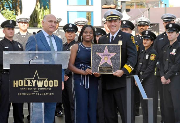 Steven Nissen, President & CEO, Hollywood Chamber of Commerce, Eniola Taiwo and LAFD Chief Jaime E. Moore (L-R) participate in an unveiling ceremony honoring the Los Angeles Fire Department with an Award of Excellence star adjacent to the Hollywood Walk of Fame in Los Angeles on Tuesday, December 2, 2025. Taiwo, 14, wrote a letter to the Hollywood Chamber of Commerce suggesting that firefighters who battled the deadly January fires were worthy of a star on the Hollywood Walk of Fame. The letter precipitated the tribute.  LAP2025121212 JIMxRUYMEN