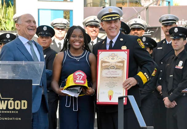 Eniola Taiwo (C) participates in an unveiling ceremony honoring the Los Angeles Fire Department with an Award of Excellence star adjacent to the Hollywood Walk of Fame in Los Angeles on Tuesday, December 2, 2025. Taiwo, 14, wrote a letter to the Hollywood Chamber of Commerce suggesting that firefighters who battled the deadly January fires were worthy of a star on the Hollywood Walk of Fame. The letter precipitated tribute.  LAP2025121213 JIMxRUYMEN