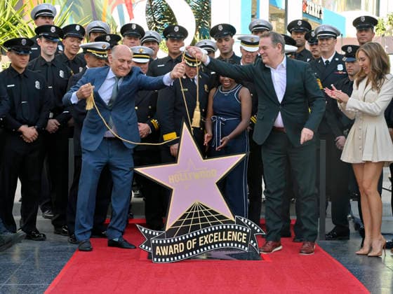 Eniola Taiwo (C) participates in an unveiling ceremony honoring the Los Angeles Fire Department with an Award of Excellence star adjacent to the Hollywood Walk of Fame in Los Angeles on Tuesday, December 2, 2025. Taiwo, 14, wrote a letter to the Hollywood Chamber of Commerce suggesting that firefighters who battled the deadly January fires were worthy of a star on the Hollywood Walk of Fame. The letter precipitated tribute.  LAP2025121214 JIMxRUYMEN