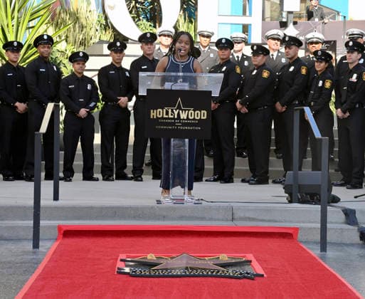 Eniola Taiwo (C) participates in an unveiling ceremony honoring the Los Angeles Fire Department with an Award of Excellence star adjacent to the Hollywood Walk of Fame in Los Angeles on Tuesday, December 2, 2025. Taiwo, 14, wrote a letter to the Hollywood Chamber of Commerce suggesting that firefighters who battled the deadly January fires were worthy of a star on the Hollywood Walk of Fame. The letter precipitated tribute.  LAP2025121216 JIMxRUYMEN