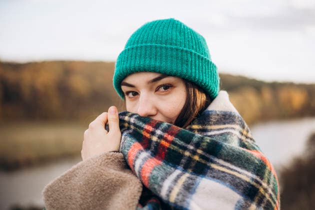 MR_ID32059_23137_AnastasiaYakimenko.jpg A woman enjoys a serene autumn walk wrapped in a warm, colorful plaid blanket and green knit beanie. She gazes softly, embracing the crisp fall air in peaceful nature. Model Released HannaYakimenko_ID32059_1091788_009 Copyright: xHannaxYakimenkox RECORD DATE NOT STATED